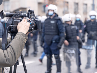 Filming riot police during crowd protest against COVID-19 coronavirus pandemic restrictions - obrazy, fototapety, plakaty