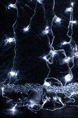 Christmas decorations: balls, tinsel, and garland, on a black background. Christmas tree toys create a desire to celebrate Christmas and New Year.