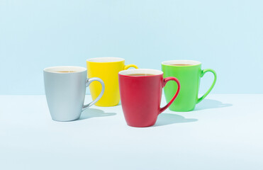 Four colorful cups on pastel background. Coffee break concept.