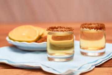Mezcal shot mexican drink with orange slices and chili pepper