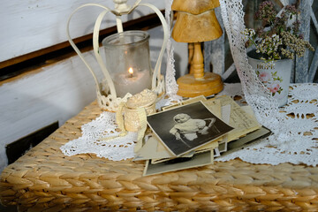 burning candle, lace, old chest of drawers shabby chic, stack of retro photos of 50-60s, dried flowers, concept of family tree, genealogy, connection with ancestors, memories of youth