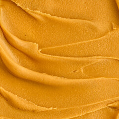 Fototapeta na wymiar Tasty peanut butter smear macro shot. Closeup of textured smooth nut food