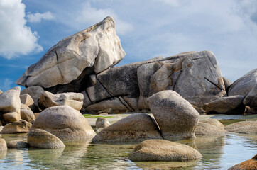 Granite boulders against the blue cloudy sky.