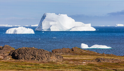 Icebergs floating in the sea off the coast of Disko Island, Greenland in sunny weather