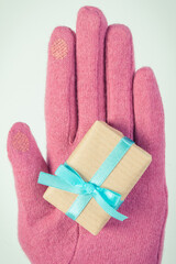 Vintage photo, Hand of woman in gloves with gift for Christmas or other celebration