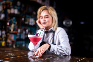 Girl bartender makes a cocktail at the public house