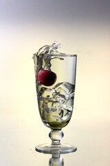 Glass with alcohol, cherry and ice