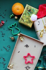 Christmas composition: wrapping gifts. Gift boxes, paper, ribbon, scissors, pasta cutters with Christmas motifs in red, green and gold