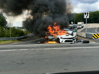A passenger car burning at the highway exit.