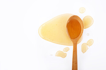 wooden spoon with honey on a white background