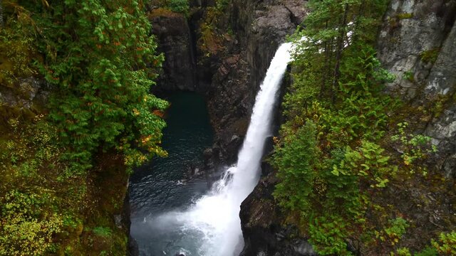 View of rocky waterfall in Elk Falls Provincial Park on Vancouver Island near Campbell River, British Columbia, Canada in autumn season surrounded by dense vegetation.