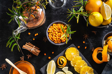 ingredients for immune sea buckthorn tea: berries, oranges, lemon, cinnamon, anise stars and honey