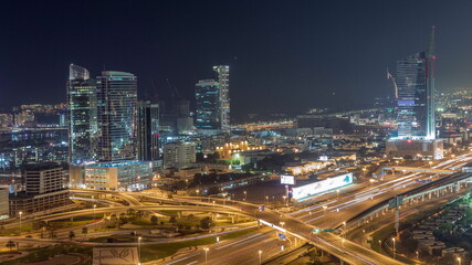 Highway crossroad and office buildings in Dubai Internet City and Media City district aerial night timelapse