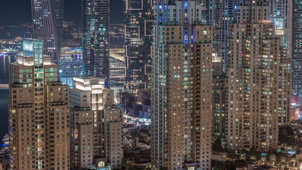 Fototapeta na wymiar Skyscrapers of Dubai Marina near intersection on Sheikh Zayed Road with highest residential buildings night timelapse