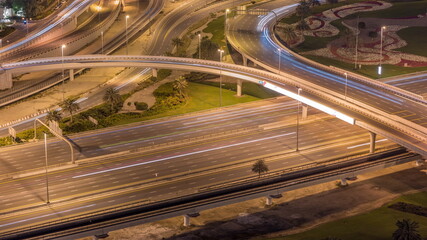 Aerial view on Dubai Marina with big highway intersection night timelapse and skyscrapers around, UAE