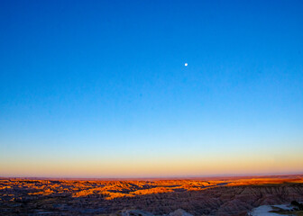 USA, South Dakota, Badlands National Park, moon setting at sunrise