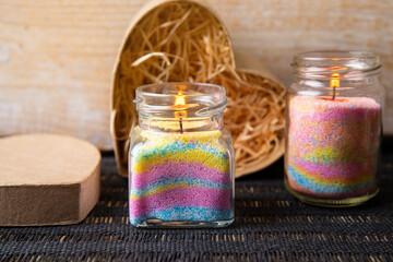 Obraz na płótnie Canvas Children made fun colorful layered wax powder candles in home by pouring powder in old baby food jar and inserting wick inside. Hobby concept.