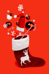 Christmas creative layout made with sock and flying bauble tree Santa Claus cap, gift boxes and snowflakes on red background. Minimal New Year or Xmas season concept. Surreal winter holidays idea.