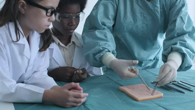 Education concept of 4k Resolution. Medical school students practicing suturing wounds in classroom. internship doctor. training simulation.