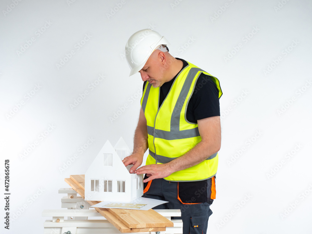 Poster a man examines the drawing and layout of the cottage. work of the architectural and construction bur
