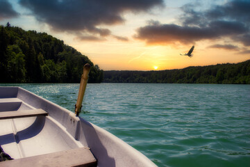 An empty boat in the middle of the lake. Dramatic sunsets and beautiful scenery