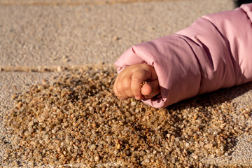 children's hand takes a handful of sand