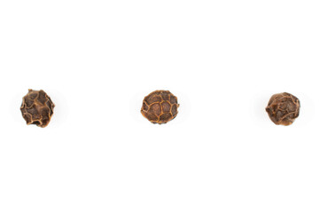 Group of three whole spicy black pepper isolated on white background in row