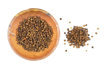 Lot of whole spicy black pepper in ceramic bowl isolated on white background with a small group of pepper aside