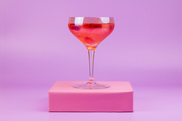 Summer cocktail with strawberries on pink background and pink podium. Refreshing summer drink abstract concept.
