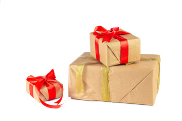 Gift box wrapped in Kraft paper with red and golden ribbon on white background. Holiday or Christmas gift boxes background.