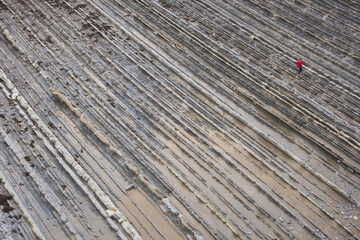 Young man walking on flysch between Zumaia and Deba, Euskadi