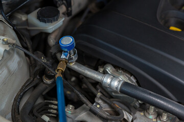 Auto mechanic monitor to check and fixed car air conditioner system in car garage. service car air conditioner in repair workshop. monitor tool on car engine ready to check and fixed air conditioner