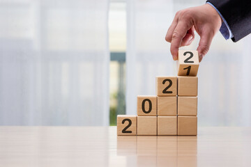 Businessman who looks forward confidently and turns calendar dates into years 2021, the concept of...