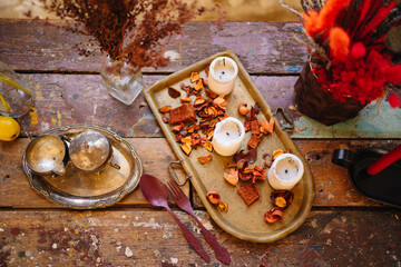 silver tableware, white candles and dried flowers on a tray as retro style decor