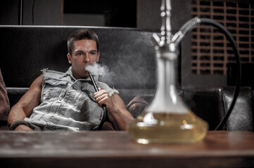 Man smoking hookah in the shisha hose.