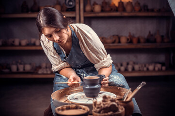 Young female potter working on a potter's wheel. - Powered by Adobe