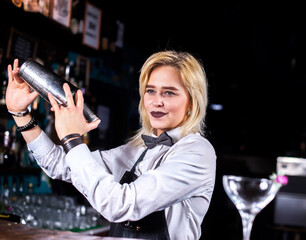 Girl barman formulates a cocktail at the beerhouse