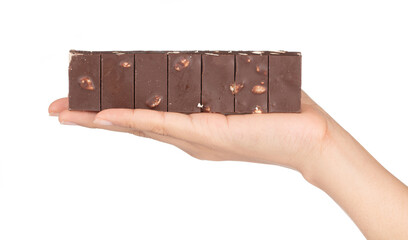 Hand holding Chocolate bar with nuts almond broken into pieces isolated on a white background
