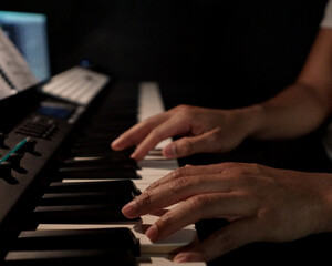 Obraz na płótnie Canvas Manos de hombre latino tocando un piano eléctrico