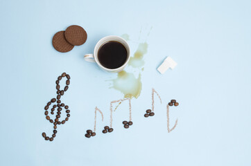 Creative morning rituals concept. Spilled black coffee, violin key and musical notes made of coffee beans and sugar. Flat lay.