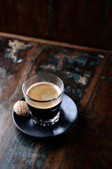 Coffee in glass cup on rustic wooden background. Copy space.