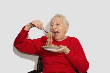 Happy senior woman eating italian spaghetti pasta isolated on white studio background