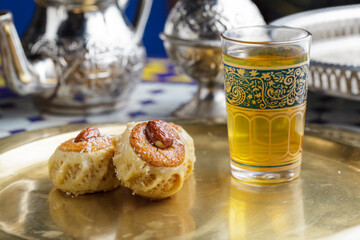 Moroccan almond pastries with mint tea on a golden tray