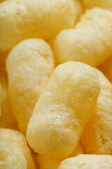 Golden corn sticks in powdered sugar close-up.