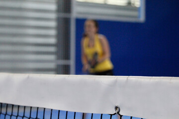 Chica joven con camiseta amarilla entrenando a padel.