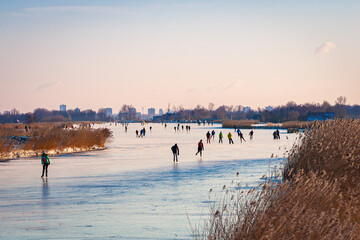 Fototapeta na wymiar Ice skaters on lake Rottemeren, close to the city of Rotterdam during a cold spell in winter