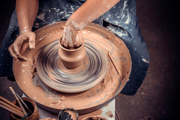 production process of pottery. Forming a clay teapot on a potter's wheel.