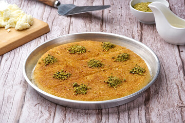 Arabian Traditional Desserts - Cream and cheeses with pistachio flavor and nuts topping on gray background