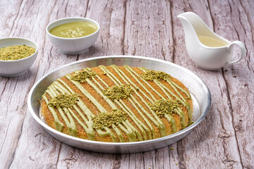 Arabian Traditional Desserts - Cream and cheeses with pistachio flavor and nuts topping on gray background