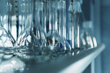 Laboratory glass flasks and test tubes on a rack.